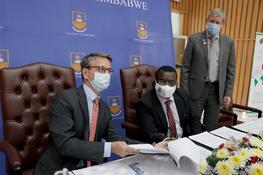 L'Ambassadeur de France, S.E. L Chevallier signe l'accord projet PACMAN, avec P. Mapfumo, Vice-Chancellor de l'Université du Zimbabwe, et B. Deprince, Directeur régional de l'AFD. © Angela Jimu - CAZCOM